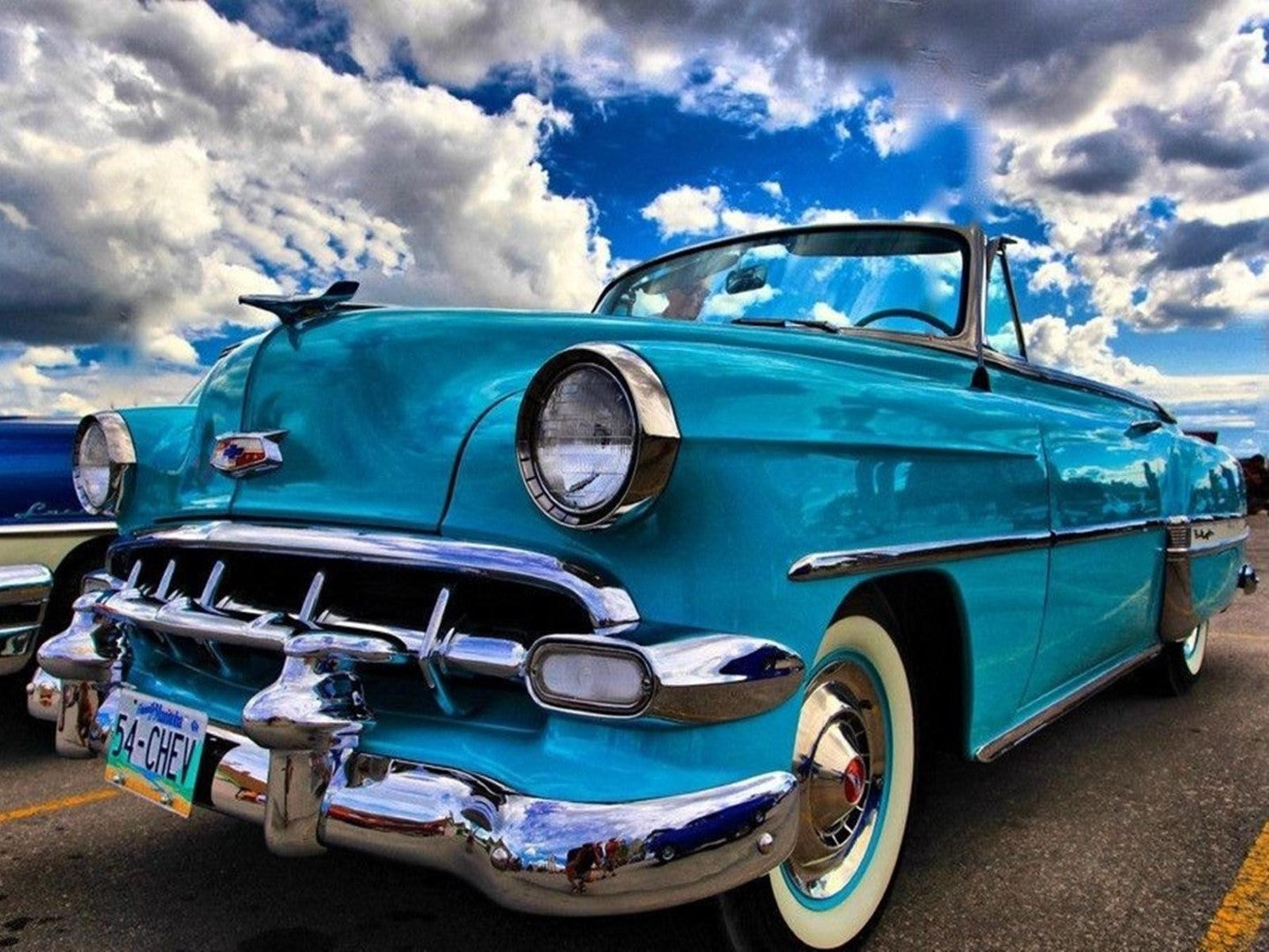 Diamond paint af en klassisk lyseblå cabriolet. Hvide skyer og blå himmel i baggrunden.