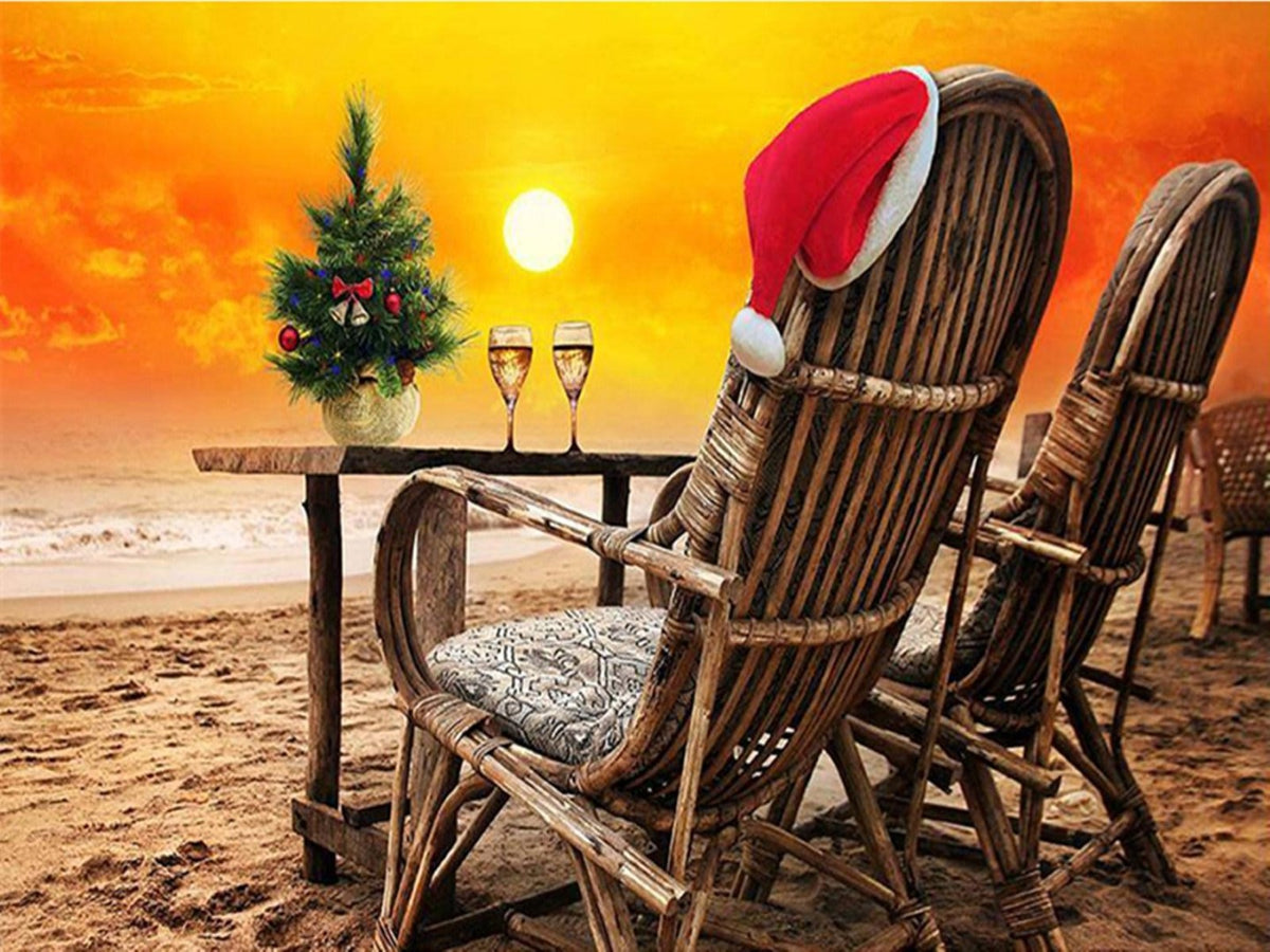 Diamond painting med drinks på stranden og nissehuen på skrå henover fletstolen.
Juletræ på strandbord.