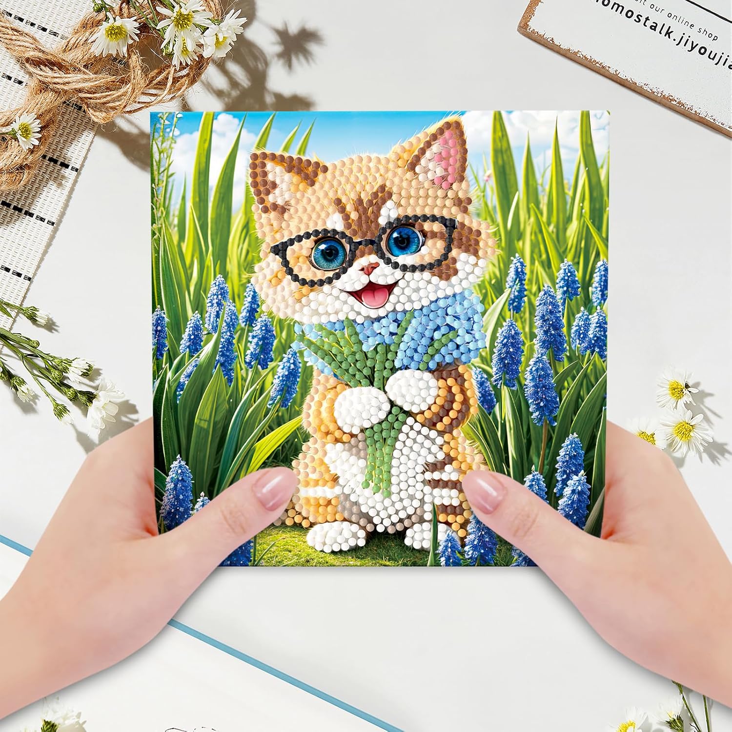 Diamond painting kort med en kat med briller omgivet af blå blomster. Foldbart kort.
