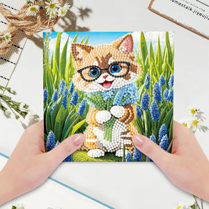 Diamond painting kort med en kat med briller omgivet af blå blomster. Foldbart kort.