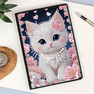 Diamond art notesbog med læder, blanke sider og en vid kat omgivet af rosa blomster på forsiden.