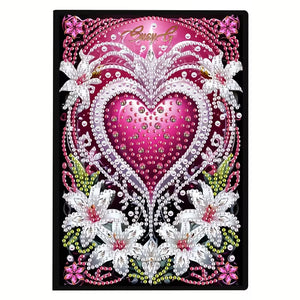 Diamond art notesbog med pink hjerte omgivet af hvide liljer og masser af glimmer.