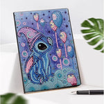 Diamond painting notesbog med Stitch i ført nathue og omgivet af balloner. Blå og lilla nuancer.