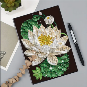 Diamond paint notesbog med hvid åkandeblomst og grønne blad. Sort notesbog.