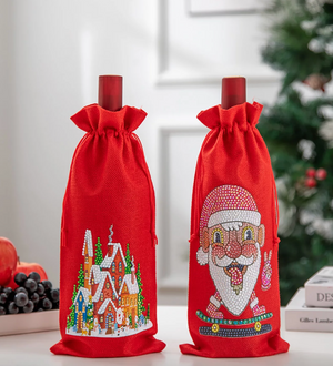 2 røde flaskeskjulere  i groft stof med motiv af nisse på skateboard og julelandsby på.