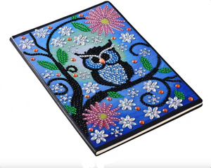 Diamond paint notesbog med ugle og blomster på blå baggrund.